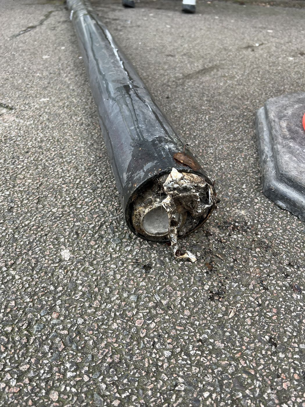Foot of a cast iron downpipe packed with silt and debris